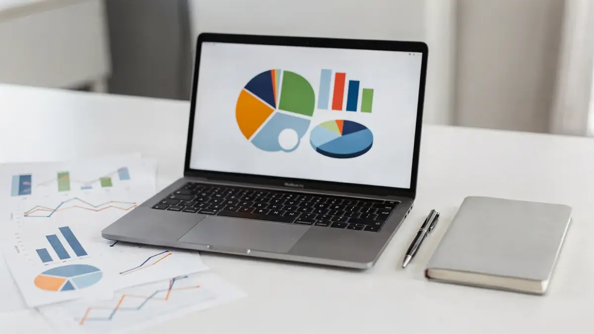 Businessplan-Zielgruppe auf Schreibtisch mit Charts, Notebook und Laptop zur Marktsegmentierung