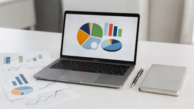 Businessplan-Zielgruppe auf Schreibtisch mit Charts, Notebook und Laptop zur Marktsegmentierung
