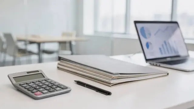 Gründungsunterlagen, Laptop und Taschenrechner zum Thema Haftung bei der Gründung