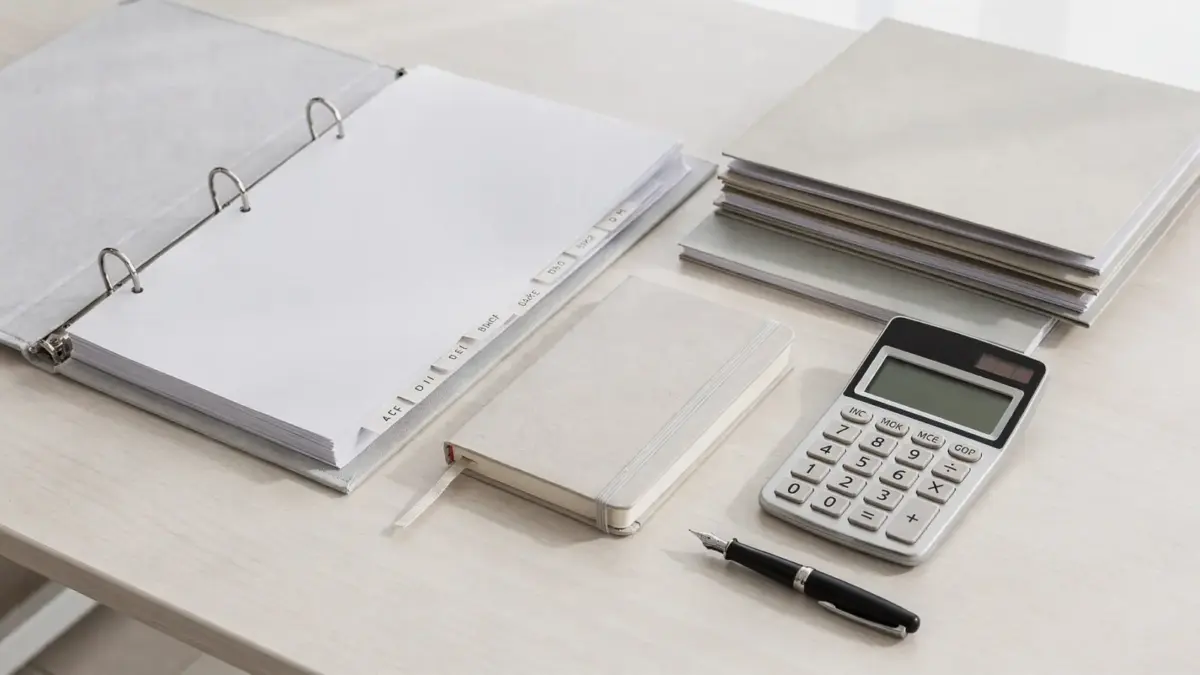 Büro-Setup zur Rechtsformwahl für ein Unternehmen mit Ordnern, Taschenrechner und Notizbuch