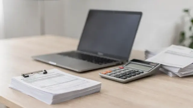 Homeoffice mit Laptop, Rechner und Unterlagen zum Thema Nebeneinkommen und Sozialabgaben